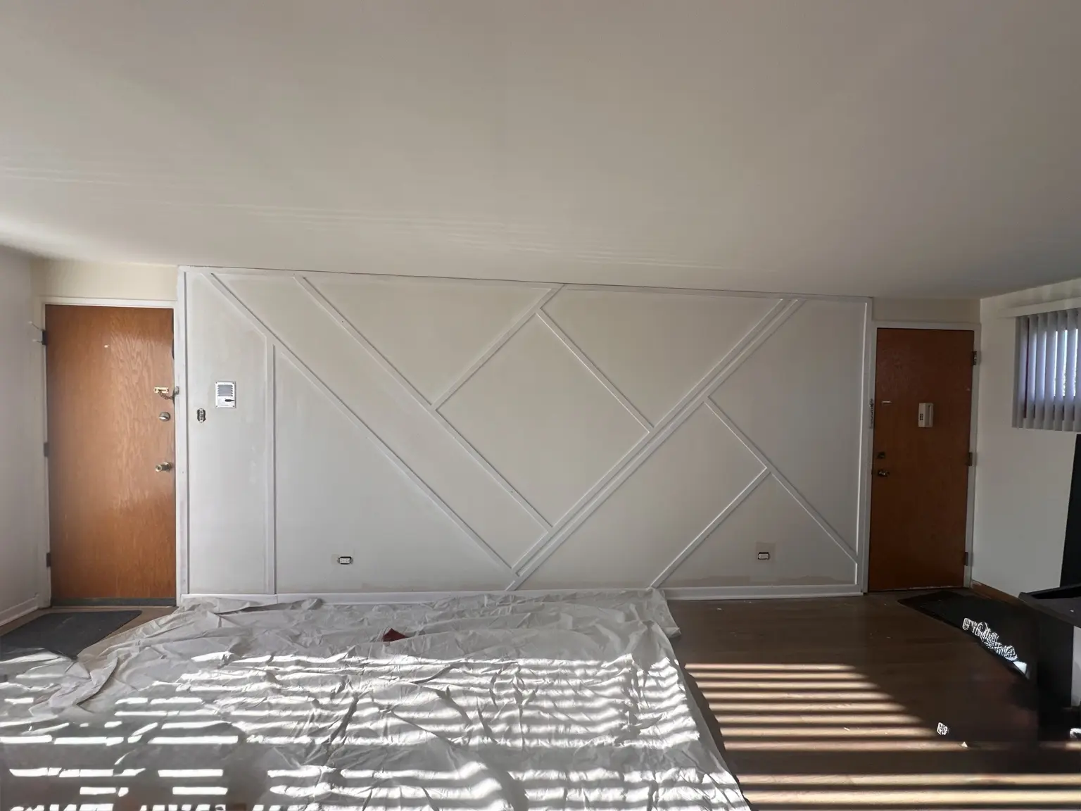Finished white geometric trim accent wall photographed in daylight