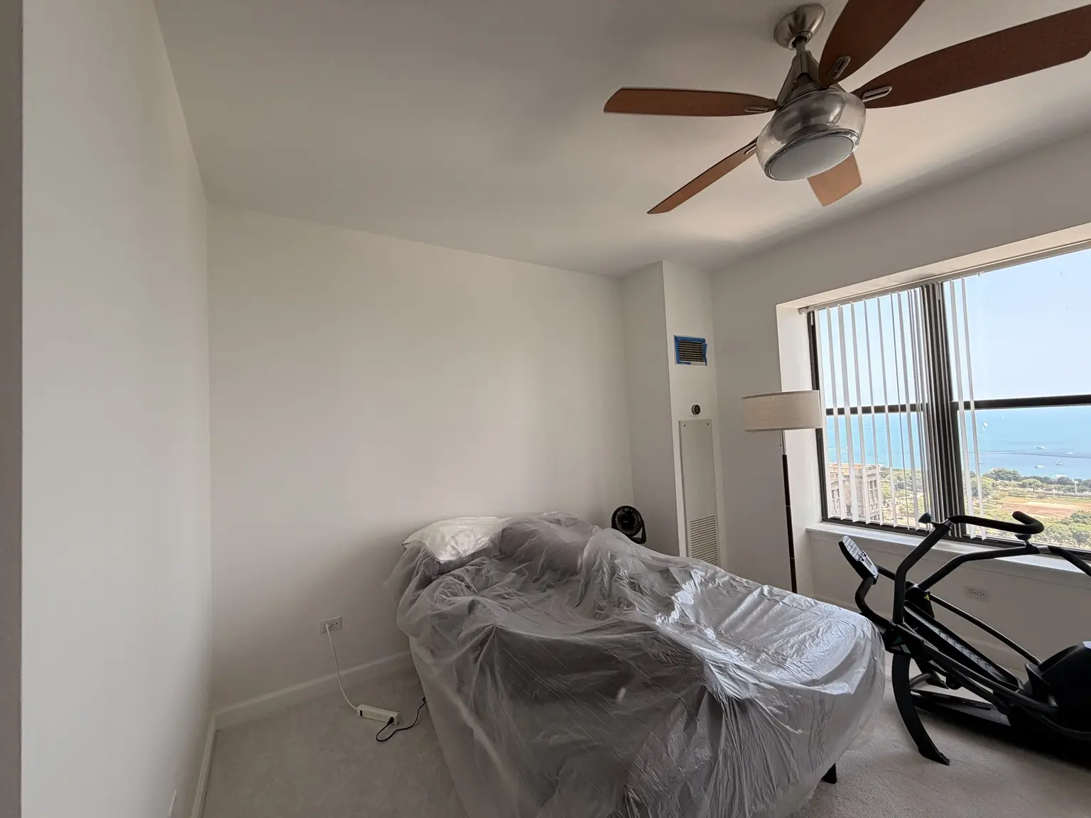 Bright freshly painted Chicago condo room with protected furnishings and lake view