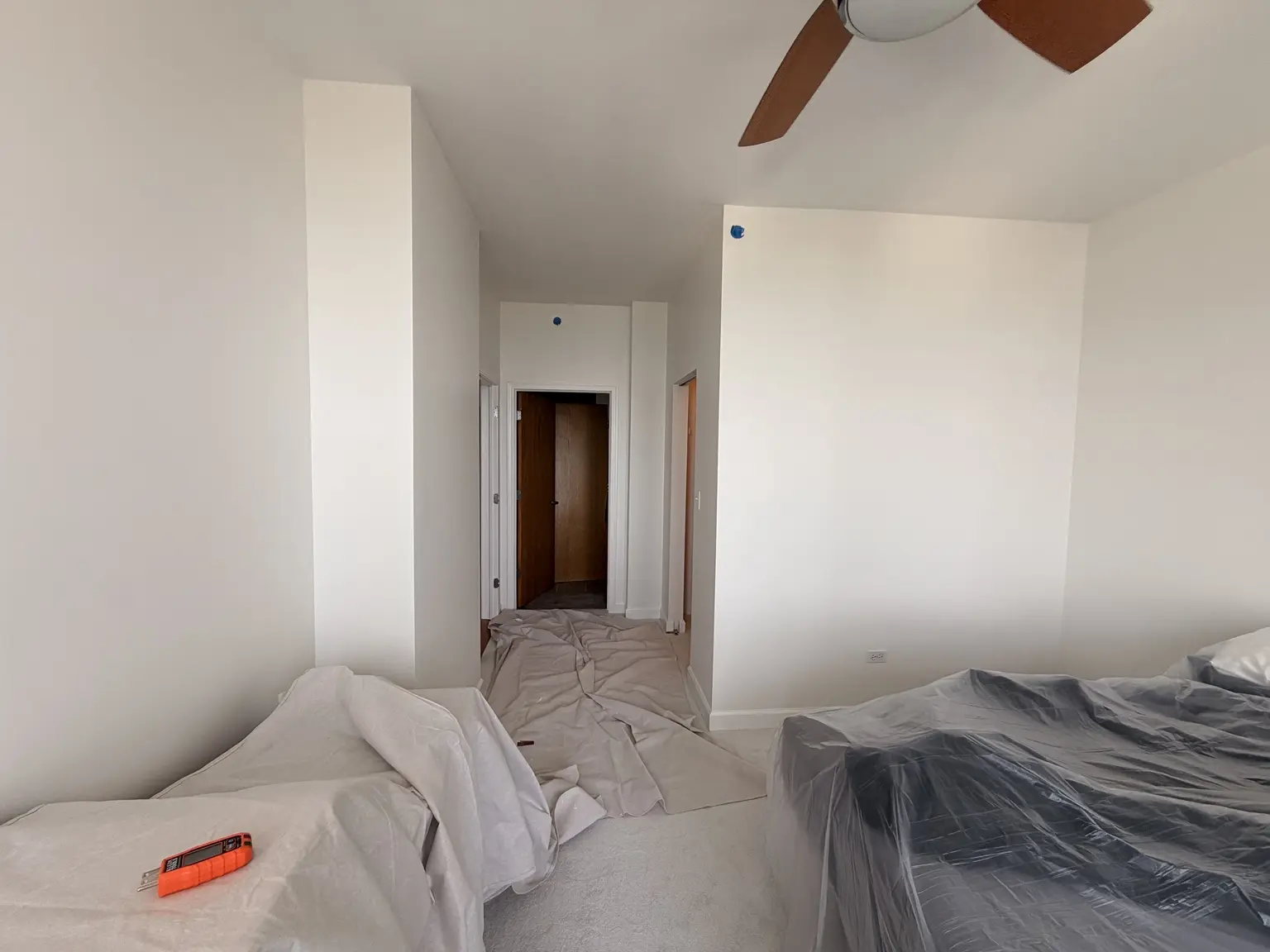 Drop cloths and plastic protection covering floors and furniture during interior painting